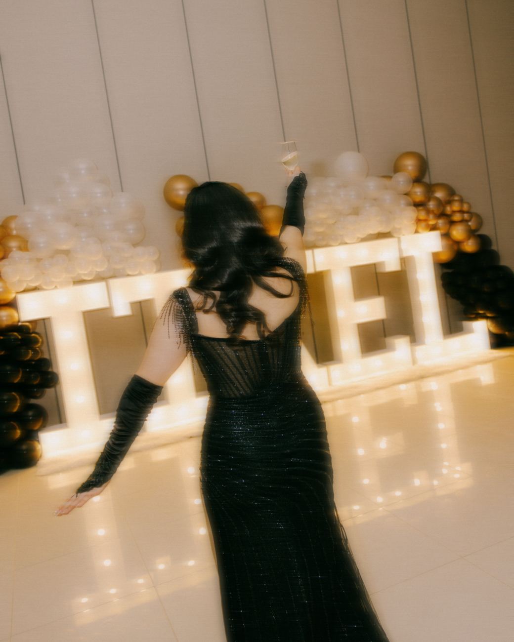 a toast at a party, marquee letters glowing through the blur