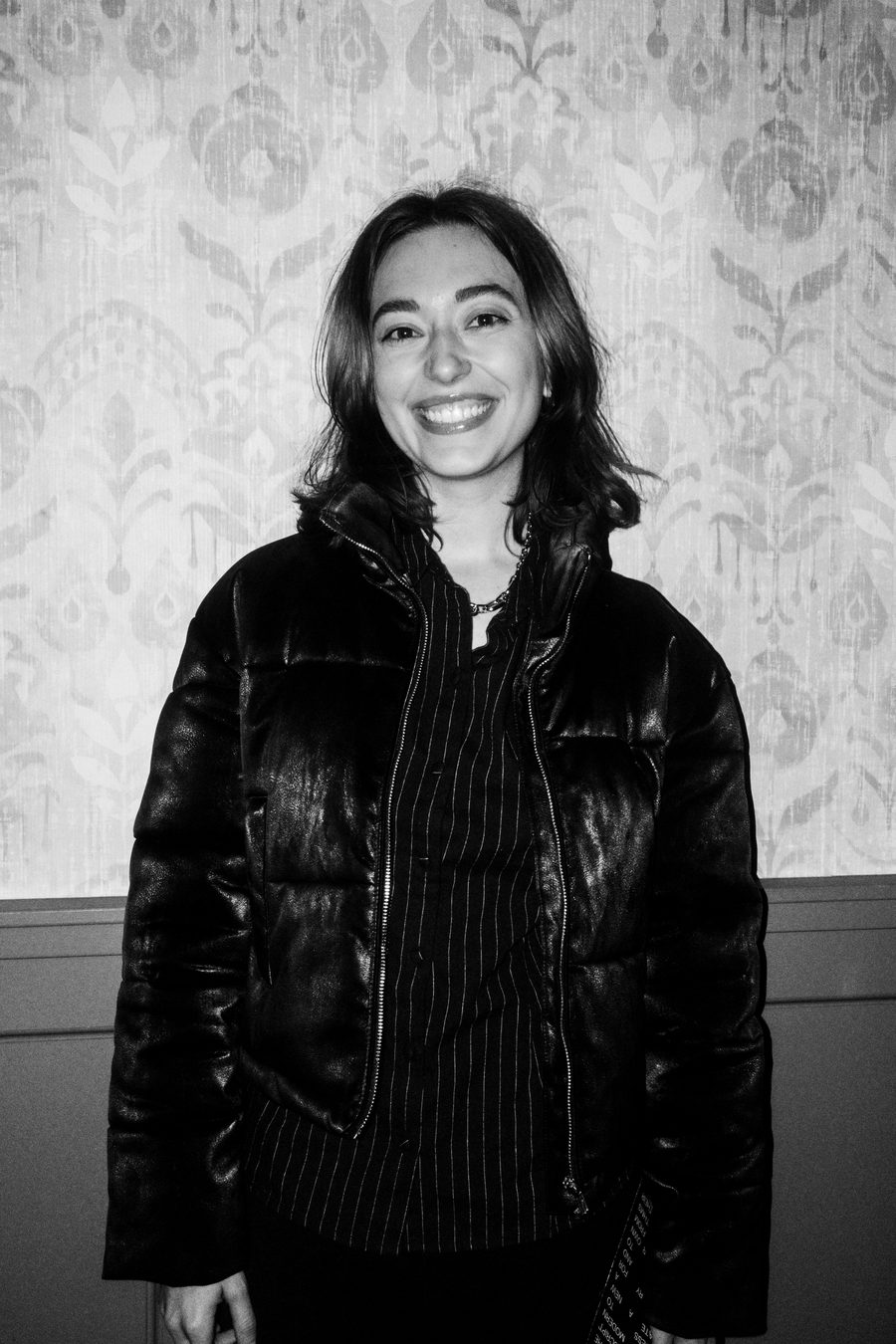 guest in a leather puffer jacket smiling