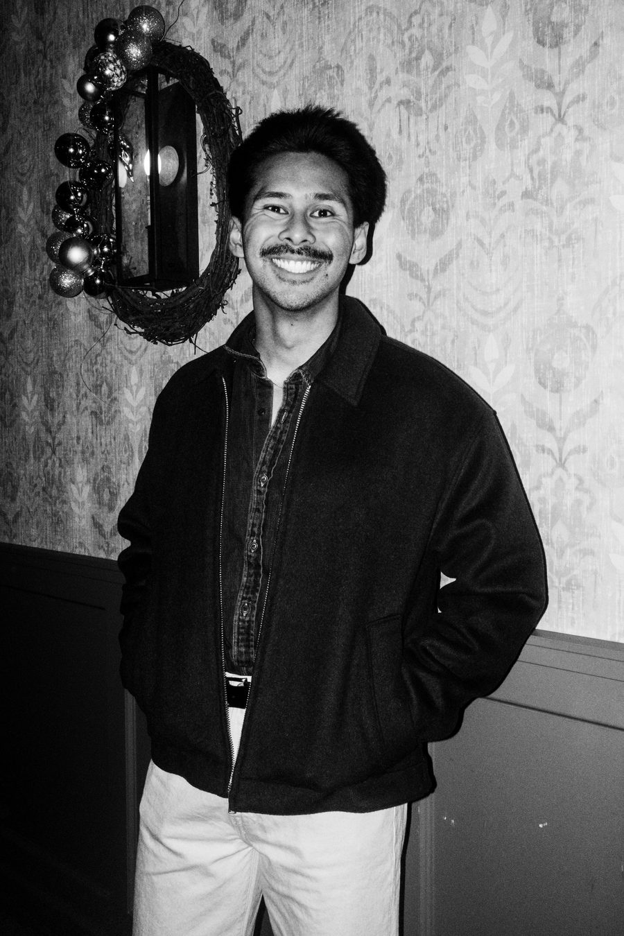 guest with a mustache in a dark chore jacket laughing