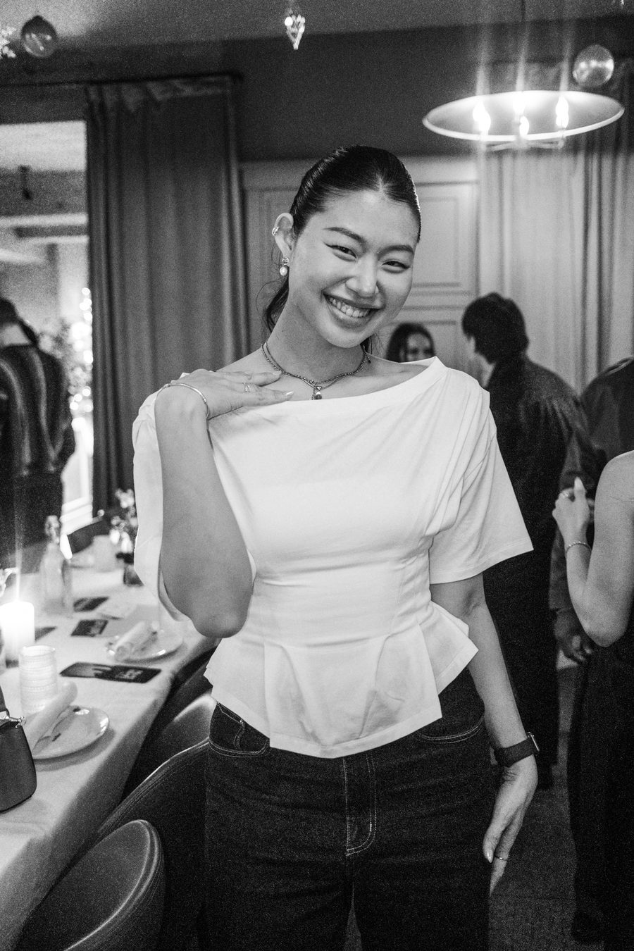 guest in a white boat-neck top laughing mid-pose