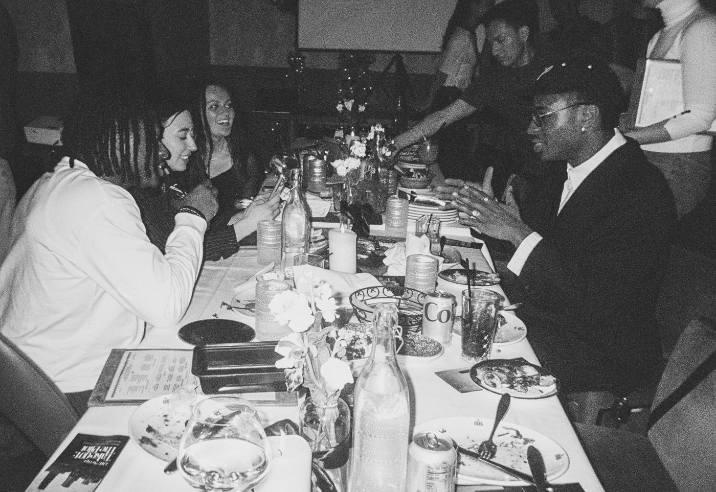 the full dinner table mid-conversation, shot on film