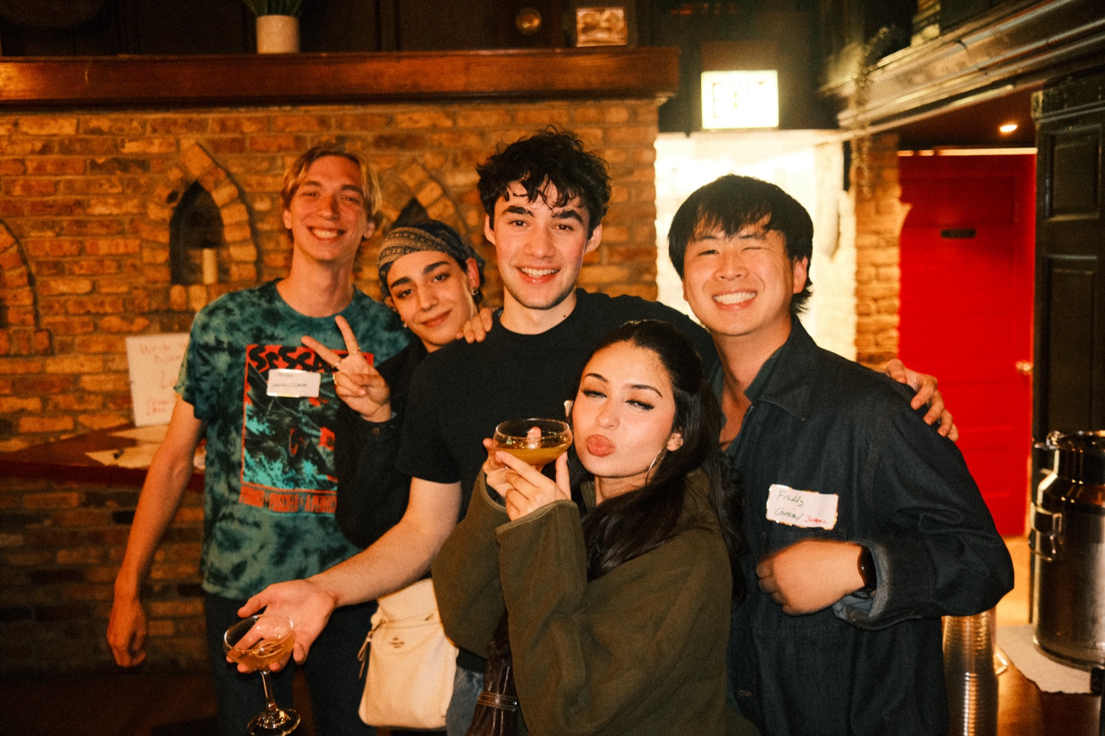 five friends arm in arm, a cocktail raised to the lens