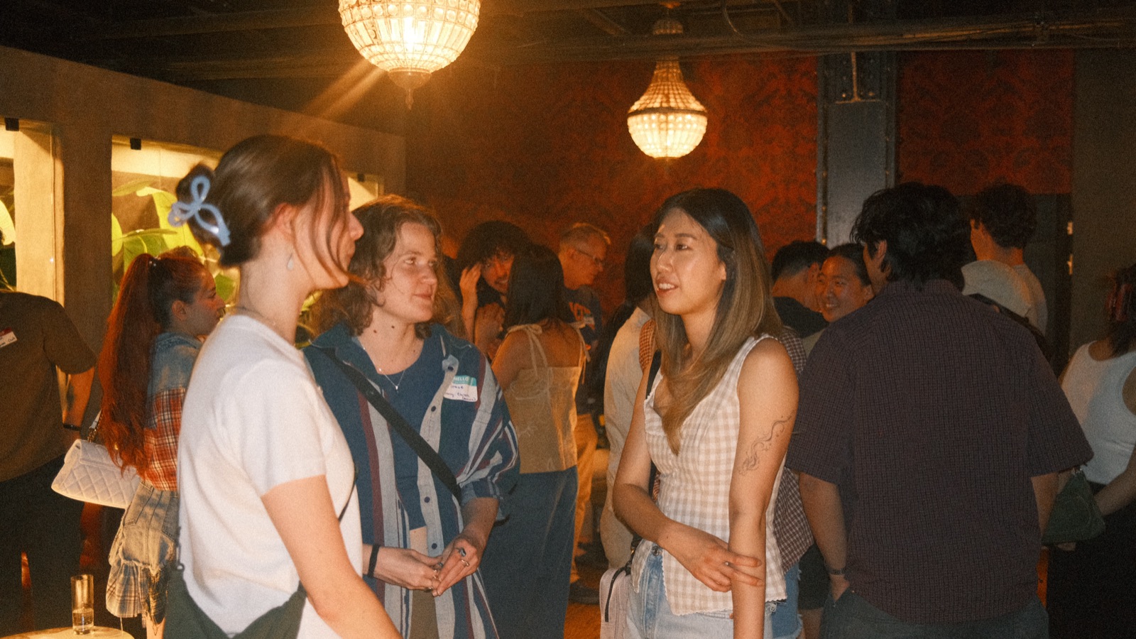 the vol 2 crowd mingling under two chandeliers