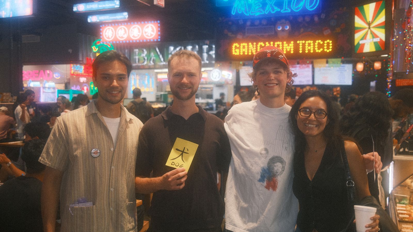 four friends under the gangnam taco neon, dog flashcard in hand