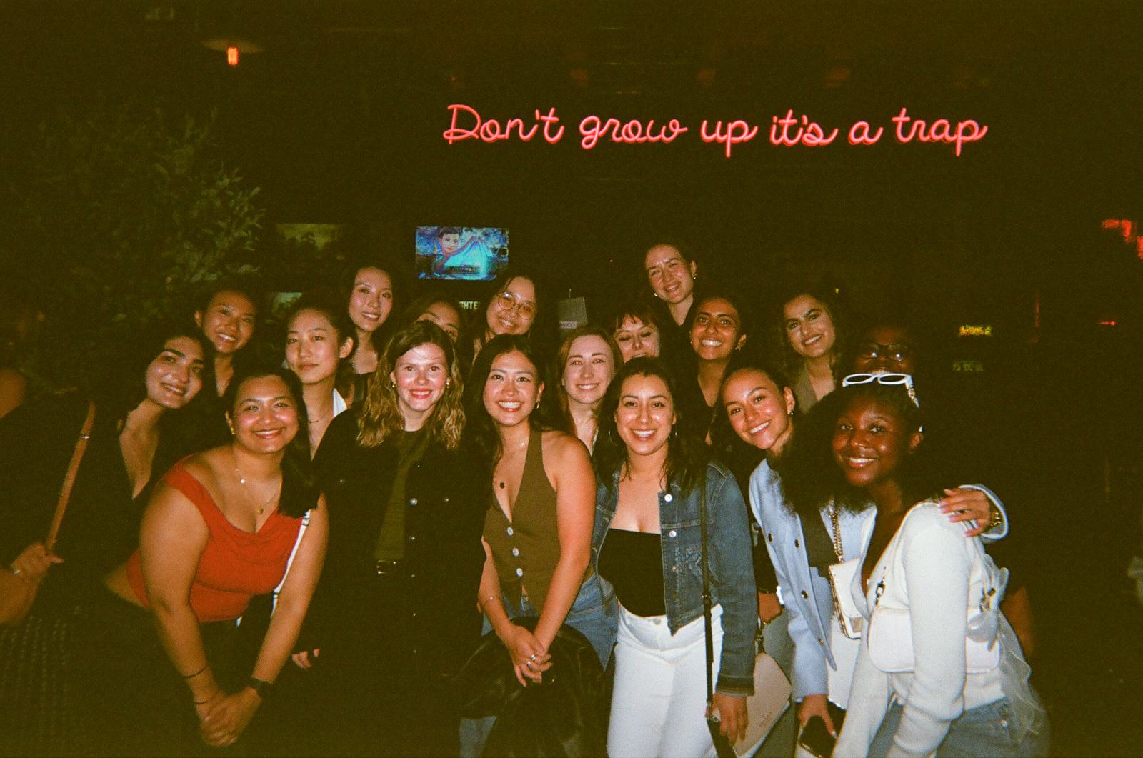 don't grow up, it's a trap — the whole room under the neon at arcade-bar night