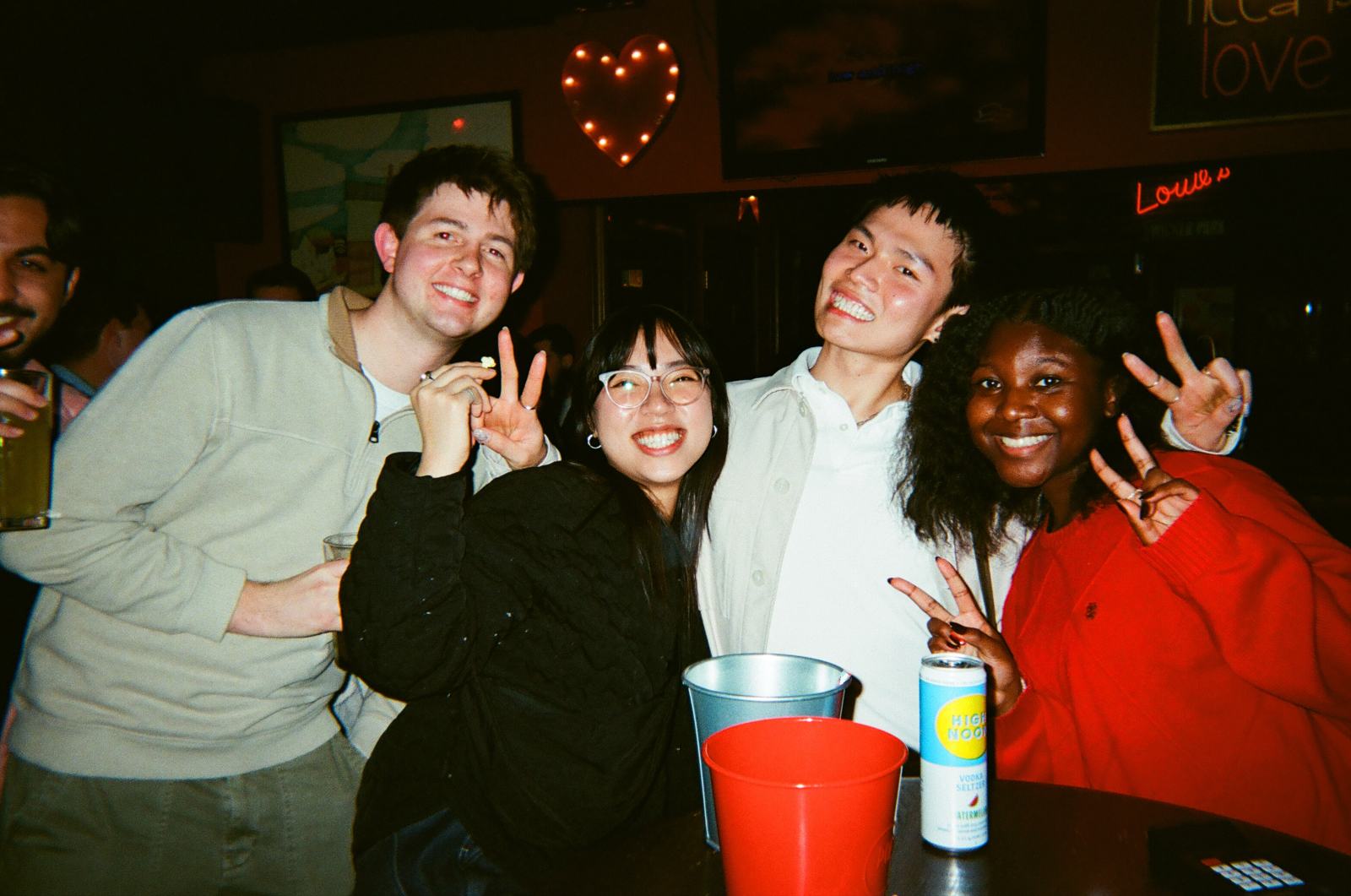 five members throwing peace signs under the heart lights — experience 11